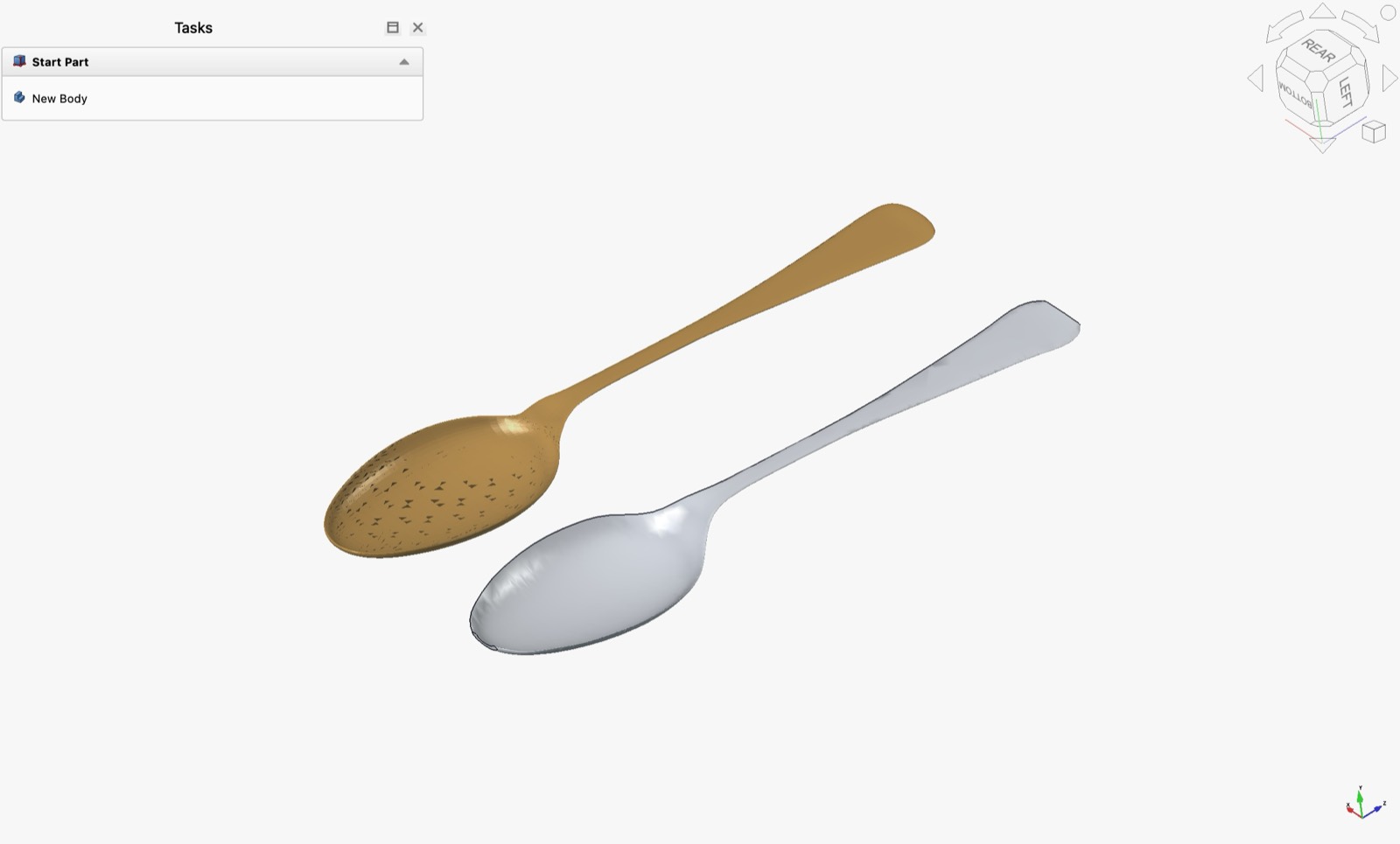 FreeCAD showing two spoons side by side: the source mesh in gold on the left, visibly faceted, and the reconstructed parametric solid in silver on the right with smooth lofted surfaces